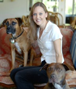 Alana Stevenson, professional dog behaviorist and trainer, with two large brown rescued pitbull dogs (2010)